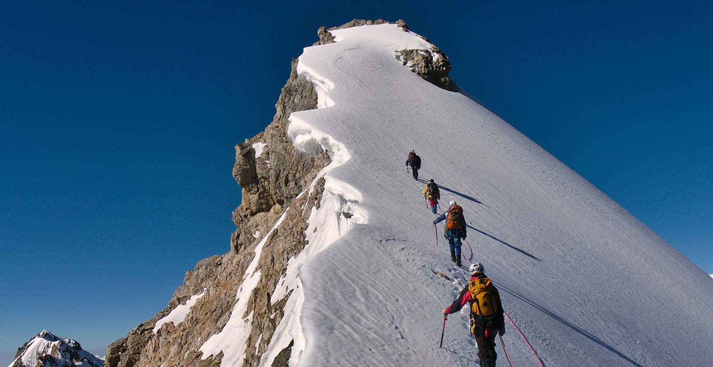 Foto eines schneebedeckten Bergs mit Bergsteigern